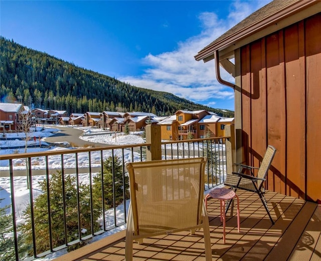 snow covered back of property featuring a mountain view