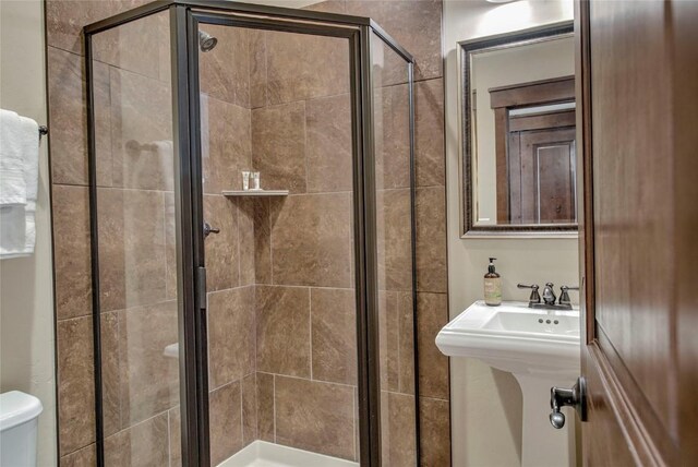 bathroom with an enclosed shower and toilet