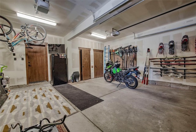 garage featuring black fridge and a garage door opener