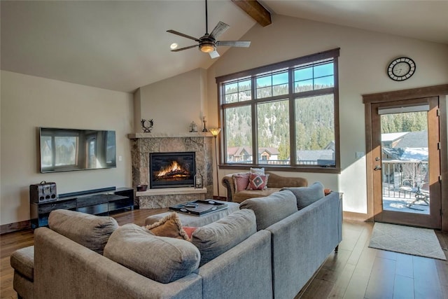 living room with beamed ceiling, ceiling fan, light hardwood / wood-style floors, and a high end fireplace