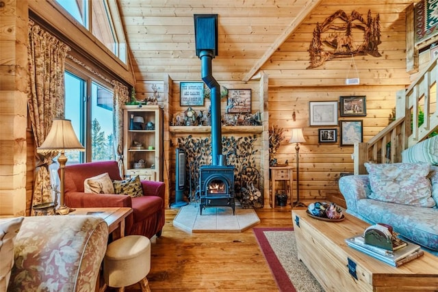 living area with a wood stove, wood finished floors, and wooden ceiling