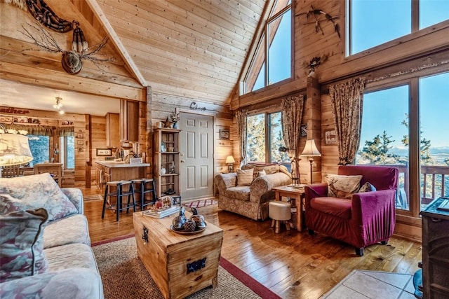 living room with high vaulted ceiling, wooden walls, hardwood / wood-style floors, and wooden ceiling