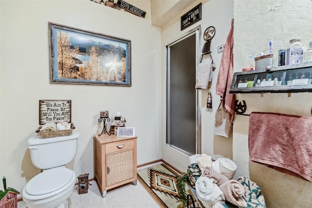 bathroom featuring toilet, baseboards, and tile patterned floors