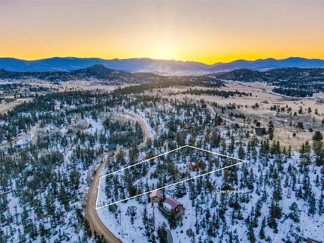 snowy aerial view featuring a mountain view and property boundaries highlighted