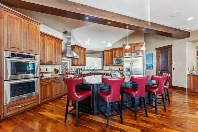 kitchen featuring built in appliances, lofted ceiling with beams, wall chimney exhaust hood, and dark wood-style flooring