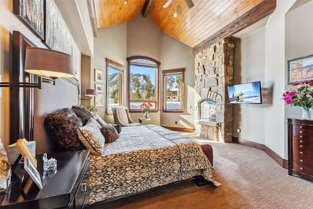 bedroom with high vaulted ceiling, a stone fireplace, wood ceiling, carpet floors, and baseboards