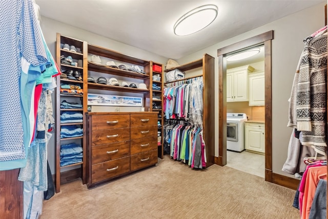 spacious closet with washer / dryer and light colored carpet