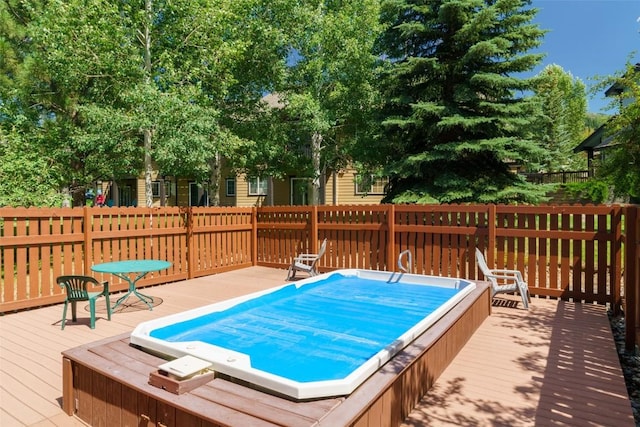 view of swimming pool featuring a wooden deck and a hot tub
