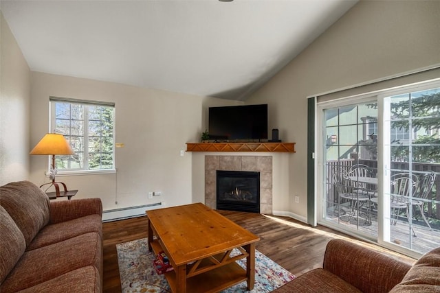living area featuring vaulted ceiling, baseboards, wood finished floors, a fireplace, and a baseboard radiator