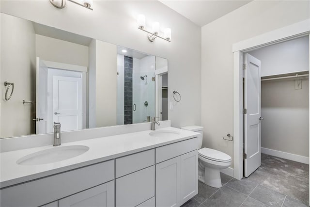 bathroom with double vanity, toilet, a stall shower, and a sink