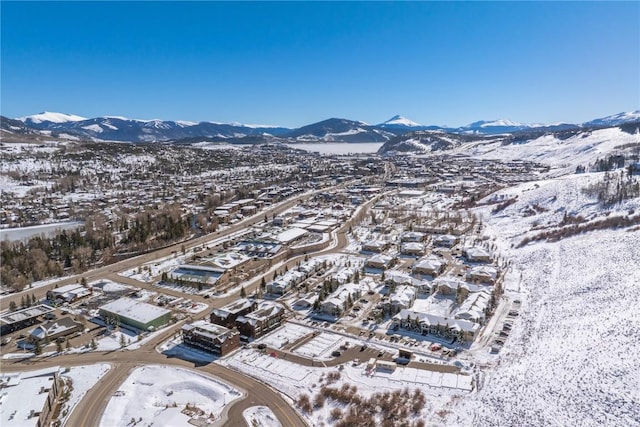 snowy aerial view with a residential view and a mountain view