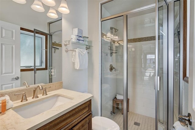full bath featuring toilet, vanity, and a stall shower
