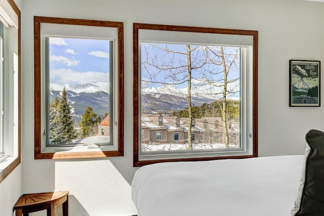bedroom with a mountain view and multiple windows