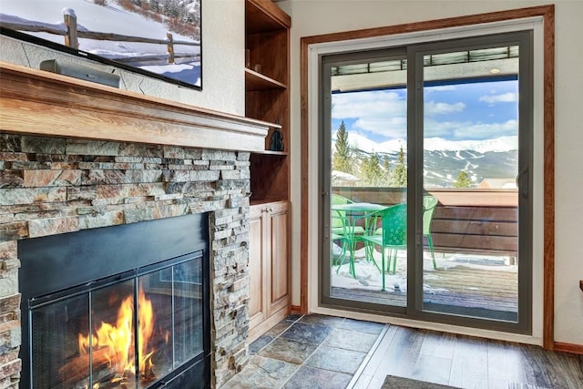 entryway with baseboards, a fireplace, and a mountain view