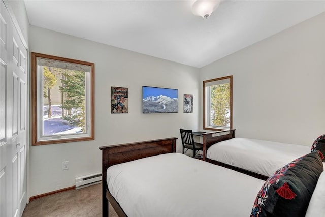 bedroom with baseboard heating, baseboards, and light colored carpet
