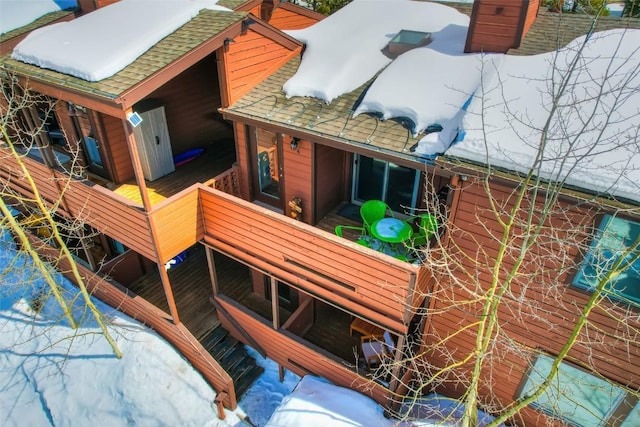 exterior space with roof with shingles and a chimney