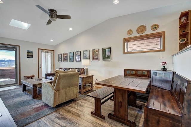living room with a ceiling fan, wood finished floors, lofted ceiling with skylight, and recessed lighting