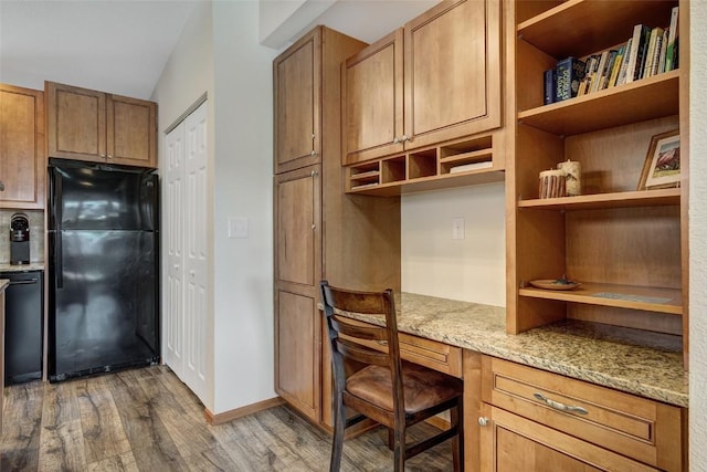 office featuring built in study area, baseboards, and wood finished floors