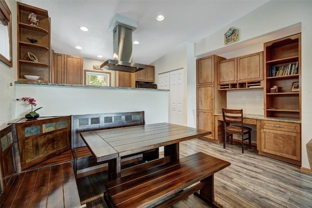 dining area with built in desk, wood finished floors, and recessed lighting