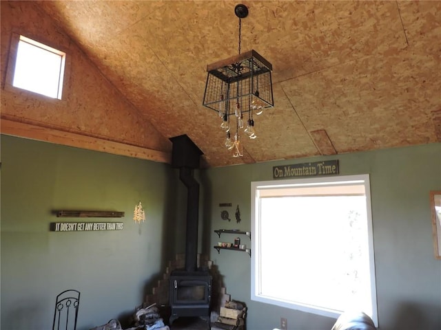 interior space featuring vaulted ceiling and a wood stove