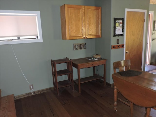 dining area featuring dark wood finished floors and baseboards