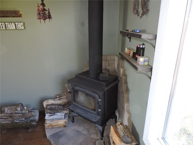 interior details with wood finished floors and a wood stove