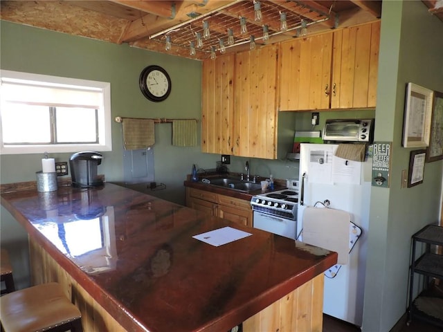 kitchen featuring dark countertops, a kitchen bar, electric range, and a sink