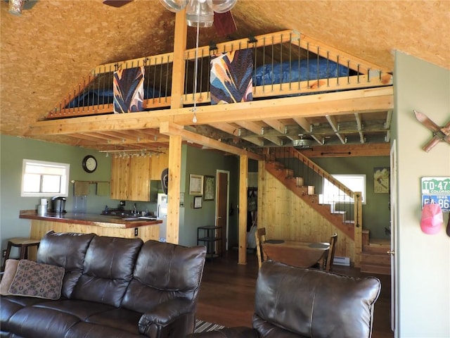 living area featuring wood finished floors, lofted ceiling, stairs, and ceiling fan