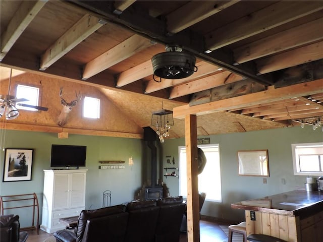 living room with a wood stove and vaulted ceiling with beams