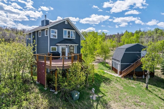 27145 Whitewood Dr E, Steamboat Springs, CO 80487 - back of property featuring a chimney, a deck, stairs, and a barn
