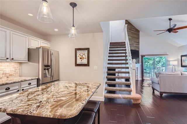 1437 Morgan Ct Unit 1437, Steamboat Springs, CO 80487 - kitchen with stainless steel refrigerator with ice dispenser, light stone countertops, open floor plan, a ceiling fan, and dark wood-style floors