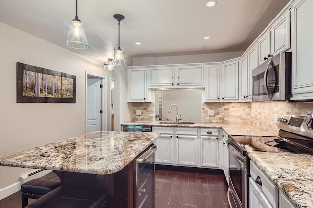 1437 Morgan Ct Unit 1437, Steamboat Springs, CO 80487 - kitchen featuring stainless steel appliances, decorative backsplash, recessed lighting, dark wood-type flooring, and a kitchen bar