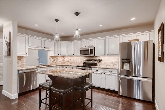 1437 Morgan Ct Unit 1437, Steamboat Springs, CO 80487 - kitchen featuring appliances with stainless steel finishes, white cabinetry, tasteful backsplash, dark wood finished floors, and recessed lighting
