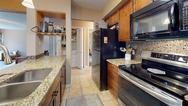 101 Blue Grouse Ln Unit D, Silverthorne, CO 80498 - kitchen with black appliances, brown cabinetry, decorative backsplash, light stone counters, and light tile patterned floors