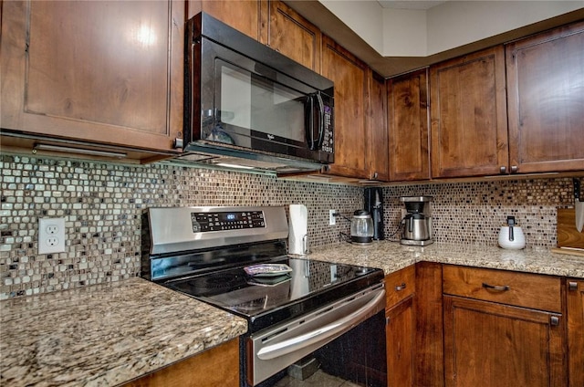 101 Blue Grouse Ln Unit D, Silverthorne, CO 80498 - kitchen with stainless steel electric range oven, black microwave, backsplash, and light stone counters