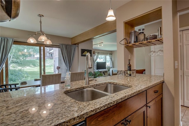 101 Blue Grouse Ln Unit D, Silverthorne, CO 80498 - kitchen with light stone countertops, brown cabinetry, decorative light fixtures, light tile patterned floors, and beam ceiling