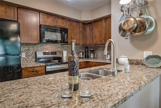 101 Blue Grouse Ln Unit D, Silverthorne, CO 80498 - kitchen featuring black appliances, backsplash, light stone counters, and brown cabinets