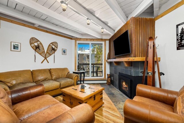 2200 Lodgepole Cir Unit 204, Silverthorne, CO 80498 - living area featuring wood ceiling, a tiled fireplace, beam ceiling, and a baseboard radiator