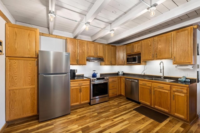 2200 Lodgepole Cir Unit 204, Silverthorne, CO 80498 - kitchen with dark countertops, wood finished floors, a sink, stainless steel appliances, and beam ceiling