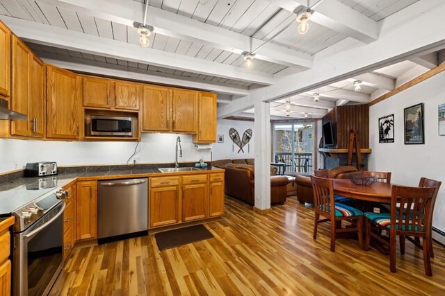 2200 Lodgepole Cir Unit 204, Silverthorne, CO 80498 - kitchen featuring a sink, open floor plan, light wood-type flooring, stainless steel appliances, and beam ceiling