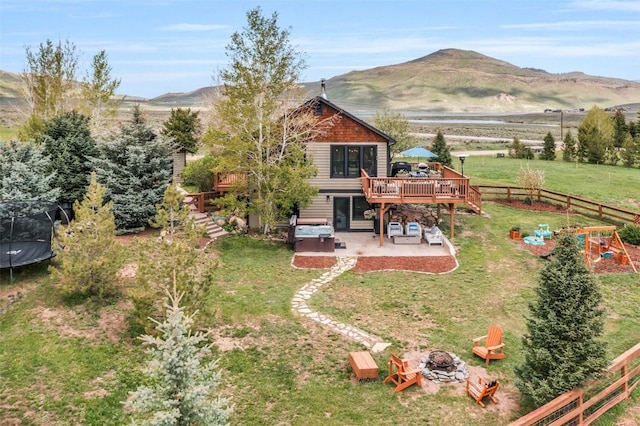 30600 Ormega Way, Oak Creek, CO 80467 - back of property with a trampoline, a fire pit, a deck with mountain view, and a patio area