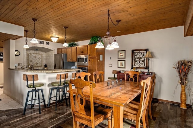 dining space with baseboards, wooden ceiling, and dark wood-style floors