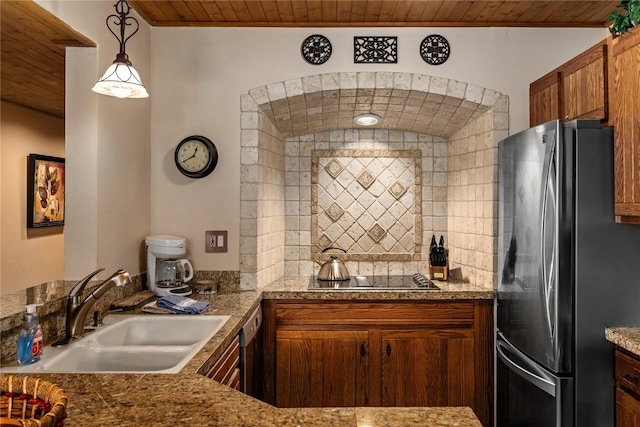 kitchen featuring wood ceiling, black electric cooktop, a sink, and freestanding refrigerator