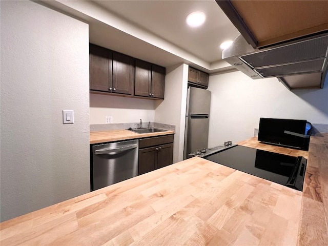 kitchen with recessed lighting, stainless steel appliances, butcher block countertops, and a sink