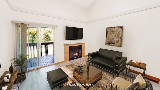 living area featuring baseboards, wood finished floors, and a tile fireplace