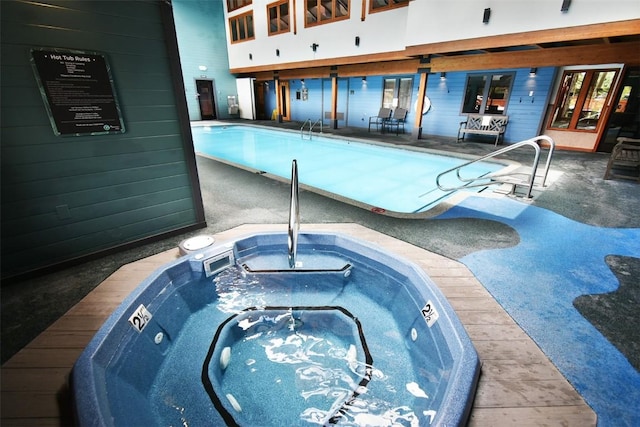 pool featuring an indoor in ground hot tub and a patio