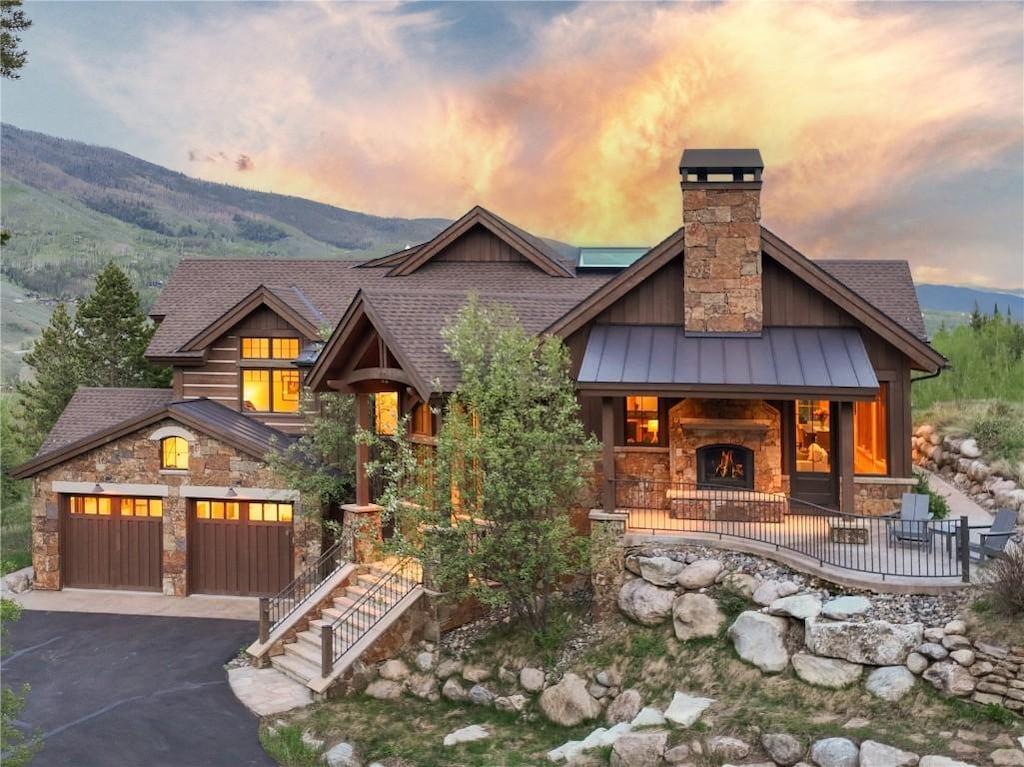 2200 Golden Eagle Rd, Silverthorne, CO 80498 - view of front facade featuring stone siding, a standing seam roof, driveway, and a mountain view