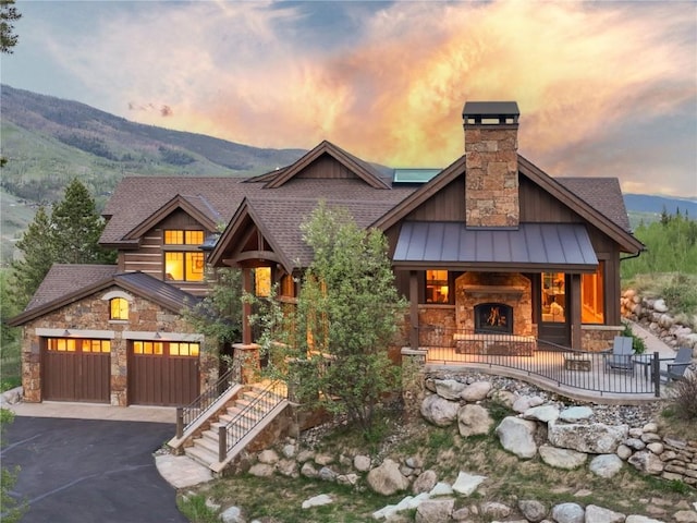 2200 Golden Eagle Rd, Silverthorne, CO 80498 - view of front facade featuring stone siding, a standing seam roof, driveway, and a mountain view