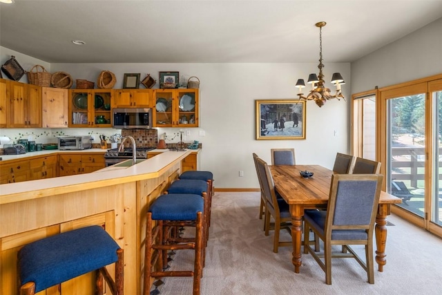 2838 Kitzbuhel Court ., Steamboat Springs, CO 80487 - dining room featuring baseboards, a toaster, a chandelier, and light colored carpet