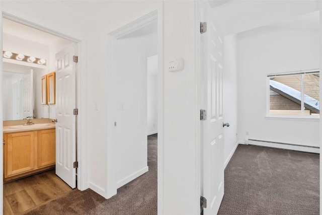 3462 Sunburst Ct Unit 36, Steamboat Springs, CO 80487 - corridor with a baseboard heating unit, dark carpet, a sink, and baseboards
